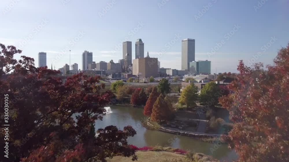 Aerial drone footage of Tulsa breaking through the trees in Autumn.