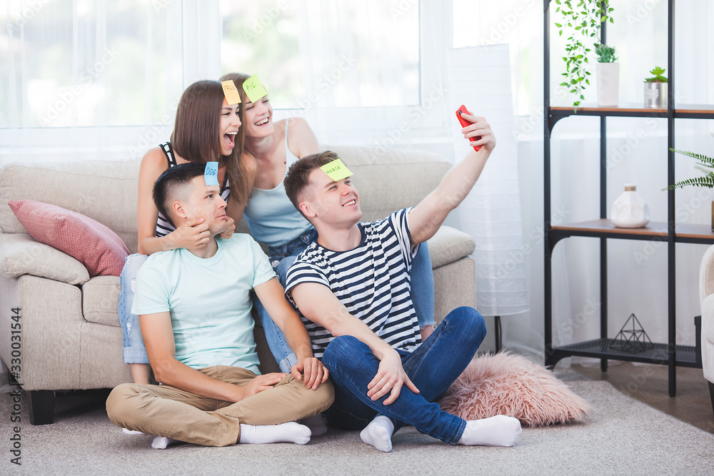 Young people making selfie indoors. Group of friends making a shot on the smartphone. People taking a pictire of themselves. Young people making selfie indoors. Group of friends making a shot on the smartphone. People taking a pictire of themselves.