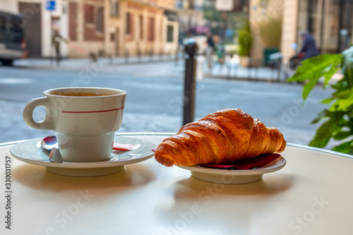 Photography Cup of Coffee and a Croissant on the Street Table