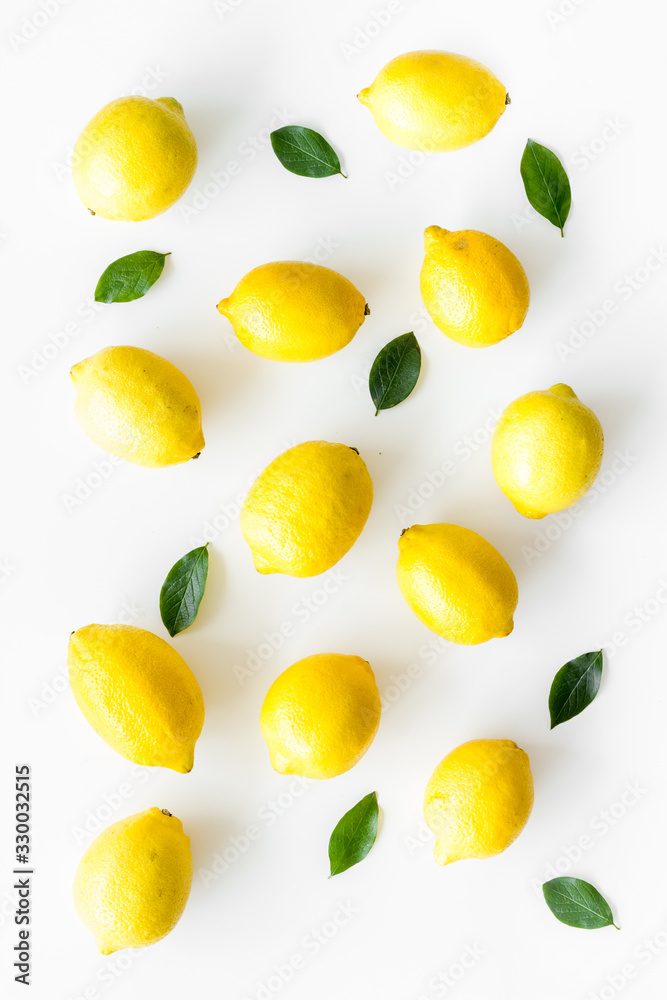 Lemons backgrond - whole fruits with leaves - on white table top-down Lemons backgrond - whole fruits with leaves - on white table top-down