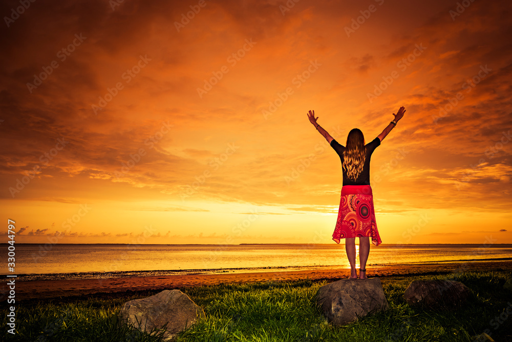 Frau mit rotem Kleid bei Sonnenuntergang am Meer Frau mit rotem Kleid bei Sonnenuntergang am Meer