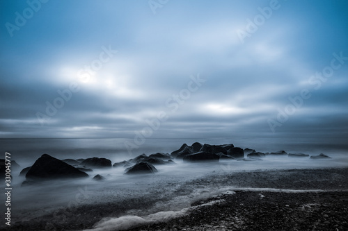 Grauer Sonnenuntergang an der Küste über dem Meer