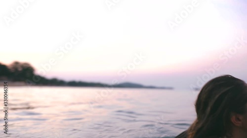Beautiful slim and young girl swims in the turquoise sea. Long hair and a slender figure in the model. A woman dives under water and splashes. The concept of calm, happiness and relaxation.