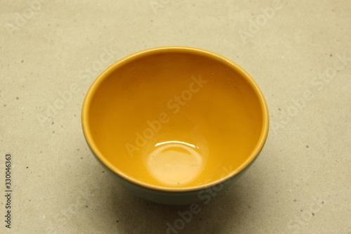 Empty ceramic bowl without a handle on a beige background