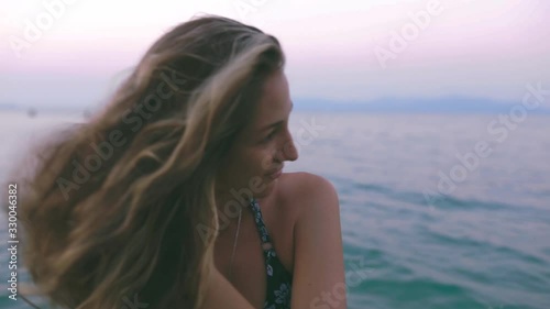 Beautiful slim and young girl swims in the turquoise sea. Long hair and a slender figure in the model. A woman dives under water and splashes. The concept of calm, happiness and relaxation.