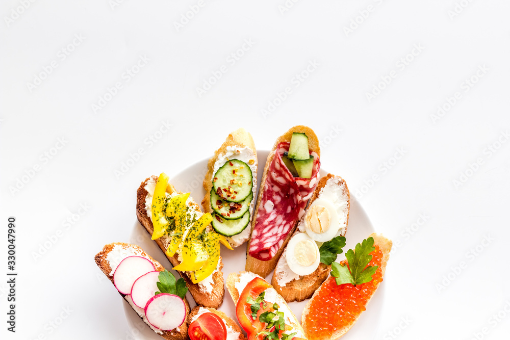 Set of bruschetta on plate on white background top-down copy space