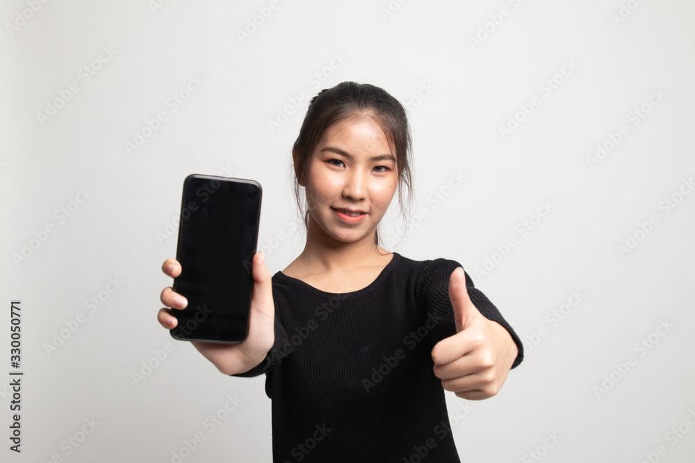Young Asian woman show thumb up with mobile phone. Young Asian woman show thumb up with mobile phone.