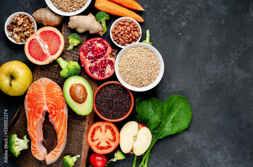 Fototapeta Naklejka Na Ścianę i Meble -  Selection of healthy food: salmon, fruits, seeds, cereals, superfoods, vegetables, leafy vegetables on a stone background   with copy space for your text.Healthy food for people 