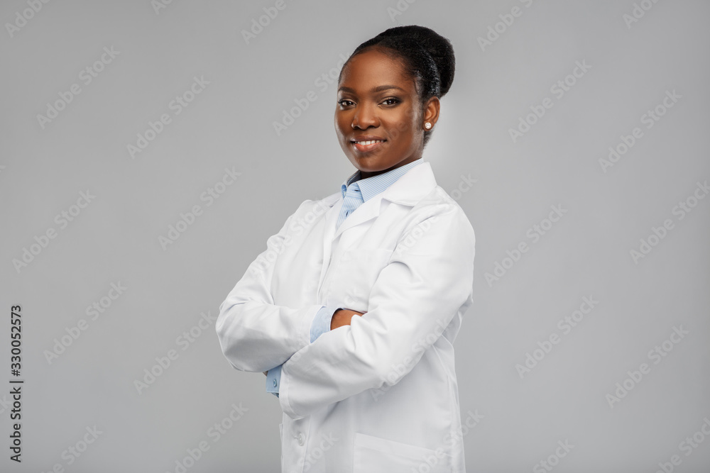 medicine, profession and healthcare concept - smiling african american female doctor or scientist in white coat with crossed hands over grey background medicine, profession and healthcare concept - smiling african american female doctor or scientist in white coat with crossed hands over grey background