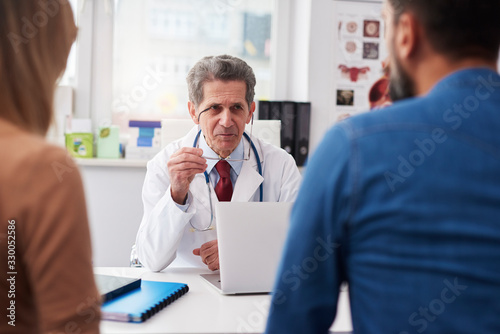 Couple talking with doctor in doctor's office © gpointstudio