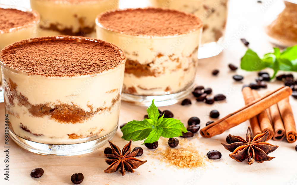 classical tiramisu dessert in a glass sprinkled with cocoa and decorated with coffee beans on a dark background, luxury dessert classical tiramisu dessert in a glass sprinkled with cocoa and decorated with coffee beans on a dark background, luxury dessert