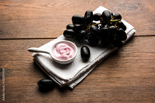 Black grapes, yogurt and honey mix face mask or cream for skin dark spot removal treatment, created using Angoor extract, curd and honey. selective focus photo