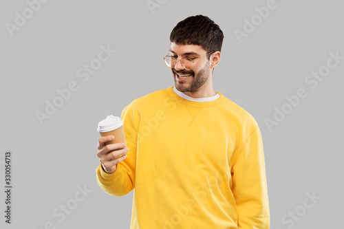 drinks and people concept - smiling young man with takeaway coffee cup over grey background