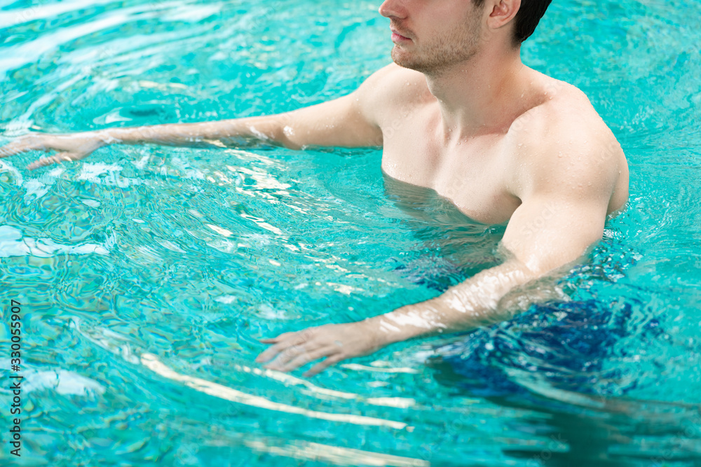 Cropped view of man training in swimming pool