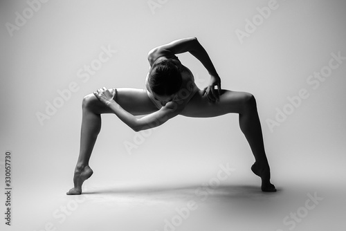 Beautiful woman dancer posing in studio. Flexible sexy woman. Black and white