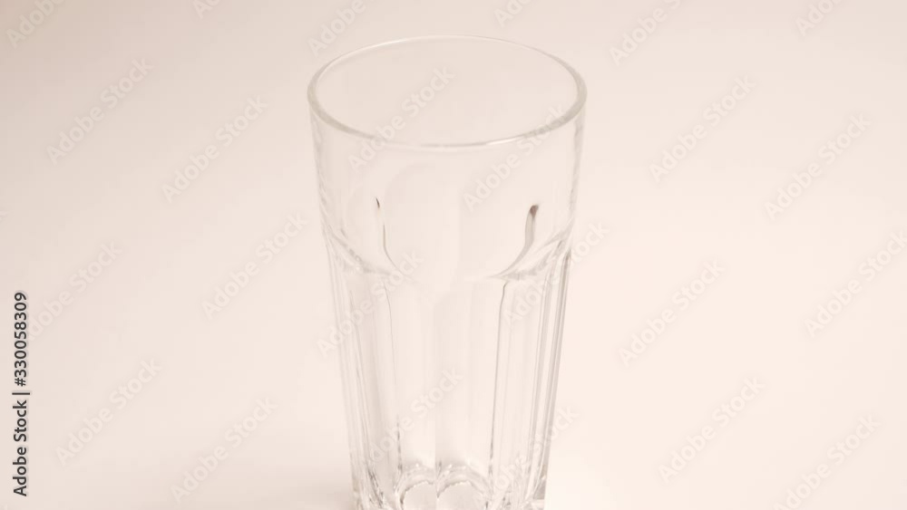 Stop motion pouring in a glass of fresh vegetarian yogurt on coconut milk. Eco milk in a transparent glass on a white background, isolated Stop motion pouring in a glass of fresh vegetarian yogurt on coconut milk. Eco milk in a transparent glass on a white background, isolated
