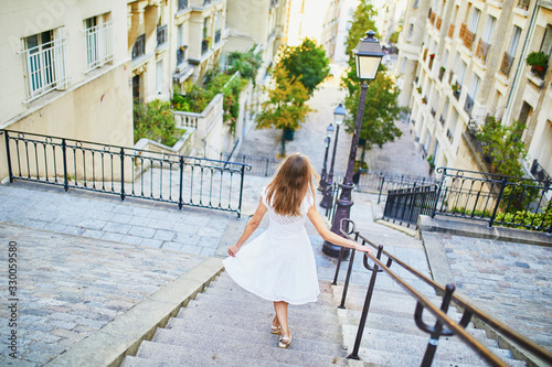 Woman in white dress walking on famous Montmartre hill in Paris, France at early morning © Ekaterina Pokrovsky