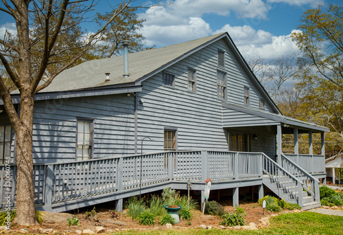 An old grey wood siding house with a wheelchair accessible ramp