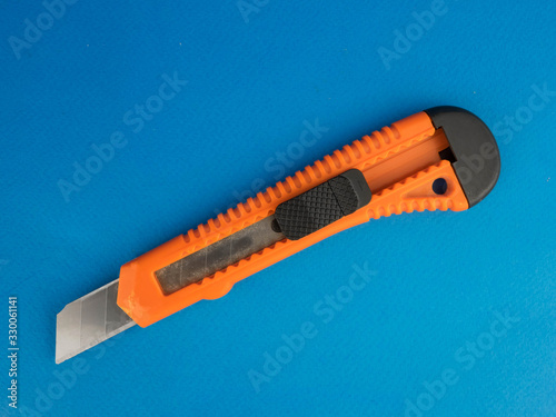 orange construction knife on a blue background