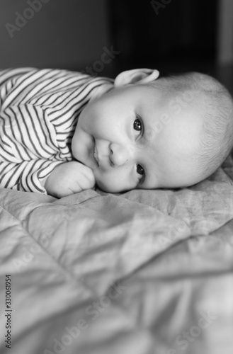 Baby boy lying on front in living room 