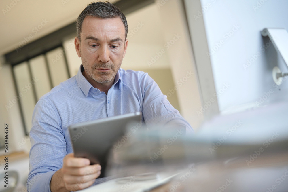 Man in office using digital tablet Man in office using digital tablet