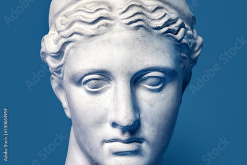 Marble head of young woman  ancient Greek goddess bust isolated on pink background. Gypsum copy of a statue Diana head
