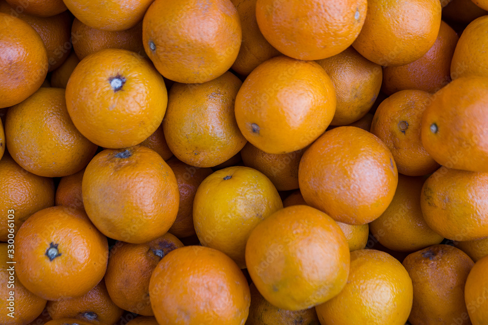 Texture, many oranges lie on the counter of a grocery store. Fresh fruits Texture, many oranges lie on the counter of a grocery store. Fresh fruits