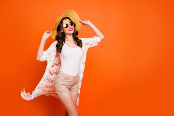 Photo of amazing lady summer time walking hot ocean sand tropical resort enjoy breeze wear sun hat specs trendy lace beach cloak shorts tank-top isolated orange background