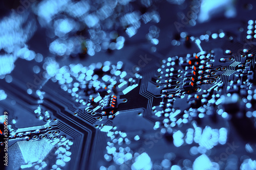 Electronic circuit board with electronic components such as chips close up. Blurry background.