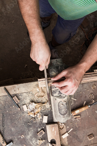 Male carpenter working on old wood in a retro vintage workshop. © astrosystem
