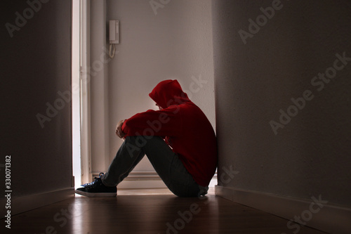 Adolescente con depresión sentado solo photo
