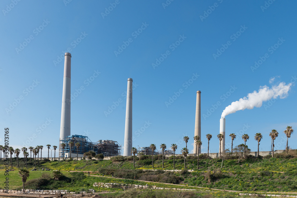 smoke rises from power plant chimneys against the blue sky. Hadera, Israel power plant smoke rises from power plant chimneys against the blue sky. Hadera, Israel power plant