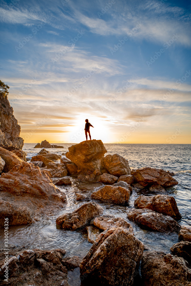 Girl in backlight on a rock on the Costa Brava in Catalonia