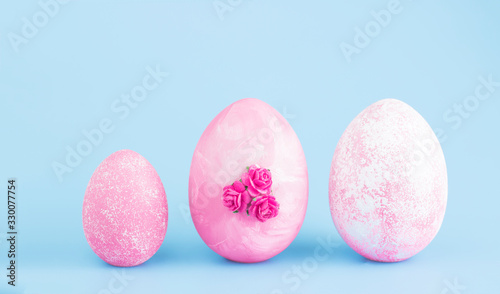 Easter eggs collection. Chicken eggs are painted pink isolated on a blue background. Creative card with Easter. Banner. Copy space