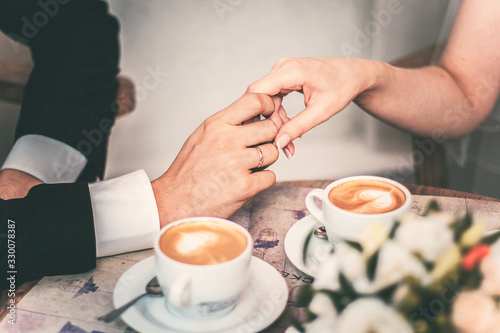 Loving couple drink coffee after the wedding. Hands newlyweds
