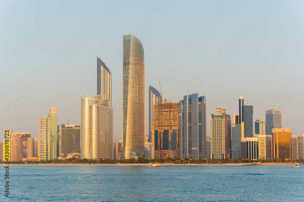 Golden hour view of Abu Dhabi financial district skyline. Luxury lifestyle hotels and business of United Arab Emirates. 