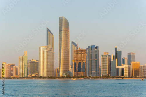 Golden hour view of Abu Dhabi financial district skyline. Luxury lifestyle hotels and business of United Arab Emirates. 
