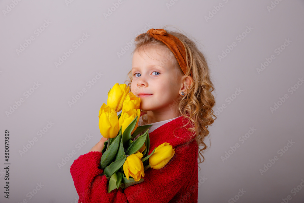 a child a blonde girl holding a bouquet of yellow tulips on a white background a child a blonde girl holding a bouquet of yellow tulips on a white background