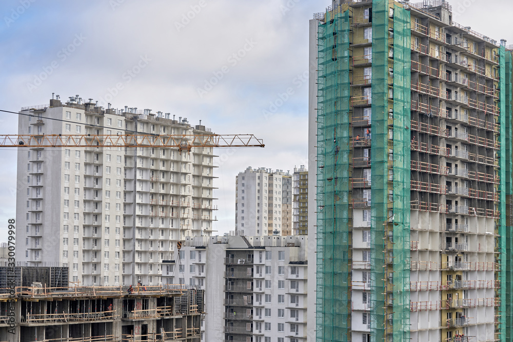 A lot of builders in helmets and masks on the top floor of a house under construction A lot of builders in helmets and masks on the top floor of a house under construction