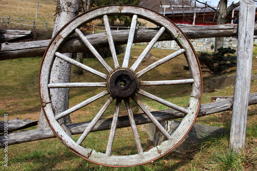 Cravegna (VCO), Italy - December 19, 2017: An old cart wooden wheel near a fence, Vigezzo Valley, VCO, Piedmon, Italy photo