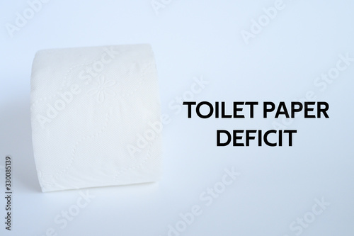 rolled white toilet paper on a white background and text toilet paper deficit. ofl font photo