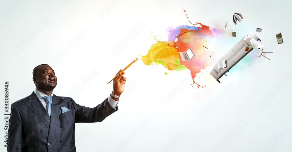Conceptual image of ambitious and creative businessman in black suit holding paintbrush in hand Conceptual image of ambitious and creative businessman in black suit holding paintbrush in hand