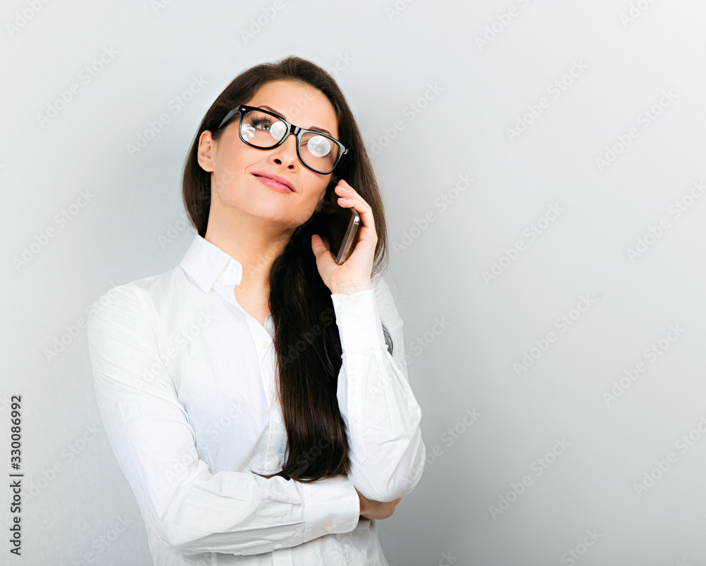 Beautiful positive business happy woman in white shirt speaking on mobile phone on blue background. Beautiful positive business happy woman in white shirt speaking on mobile phone on blue background.
