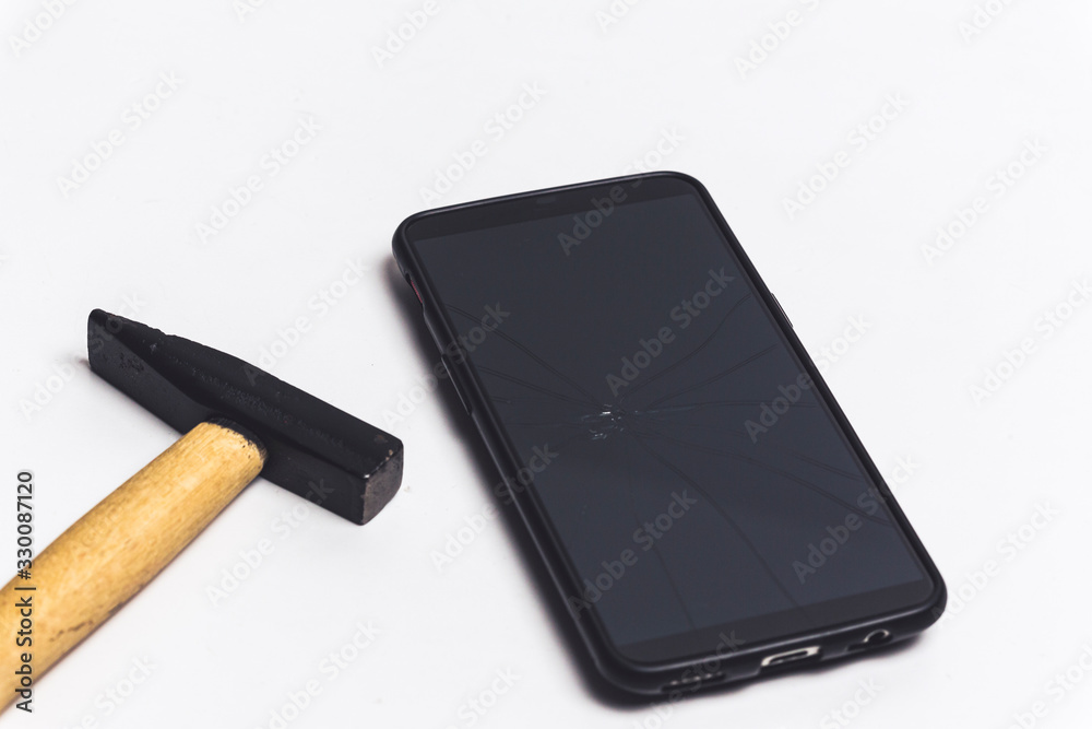 a hammer and a broken phone glass over white background - stop addiction to phone concept a hammer and a broken phone glass over white background - stop addiction to phone concept