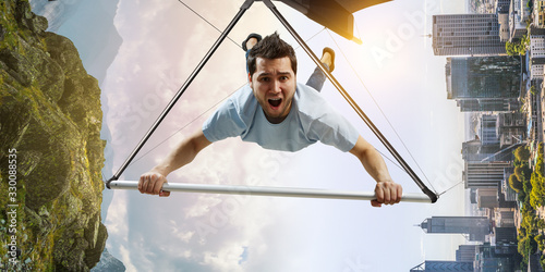 Foto Young man flying on hang glider. Mixed media