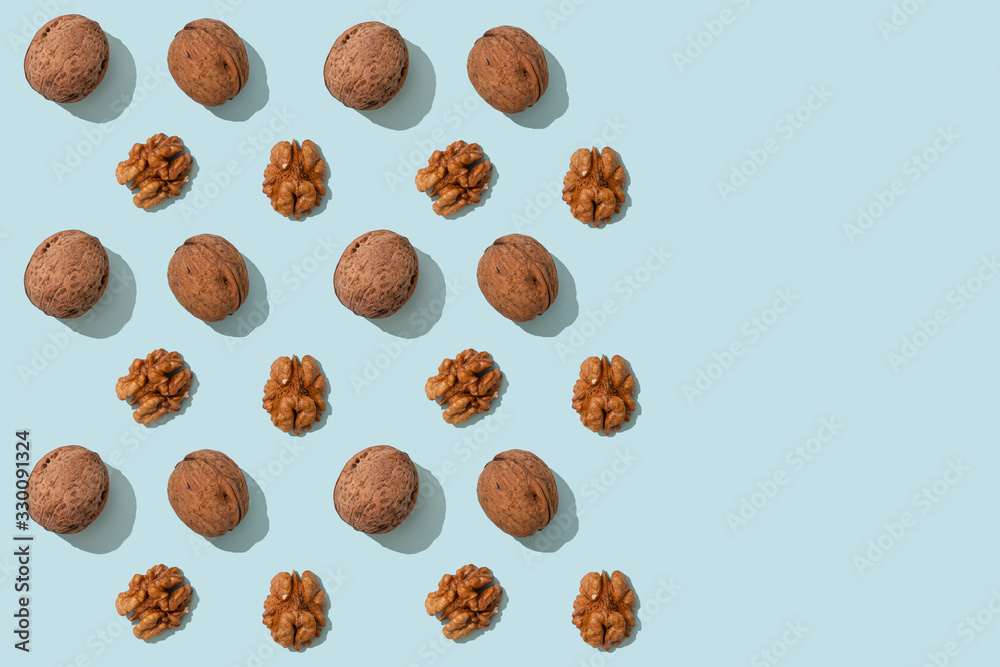Walnuts pattern, whole and peeled on blue background with copy space. Top views of the nuts and seeds. Wrapping paper, poster, greeting card, cover, sale background Walnuts pattern, whole and peeled on blue background with copy space. Top views of the nuts and seeds. Wrapping paper, poster, greeting card, cover, sale background
