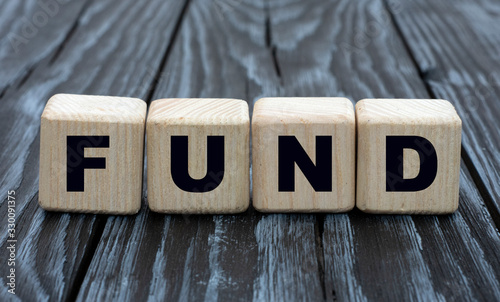 concept word fund on cubes on a dark wooden background