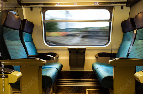 Moving train four empty coach seat blue upholstery swiss sbb rail network photo