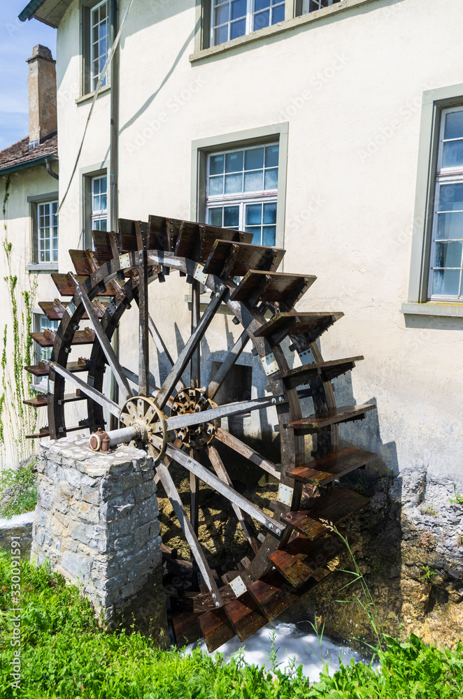 Old water mill wheel next to old building in Schaffhausen Switzerland sunny day
