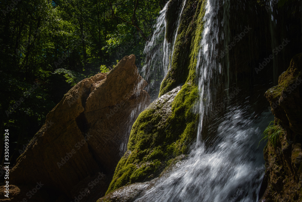 A beautiful waterfall deep in the forest, steep mountain adventure in the rainforest.